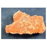 Small Orange Rock Fragment on Blue Surface