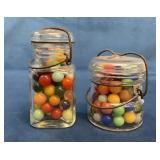 Two Glass Jars With Assorted Marbles