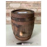 SMALL WOODEN BARREL WITH RUSTED BANDS AND A
