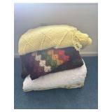 Stack of Three Blankets: Crocheted Yellow, Floral Crochet, and Quilted