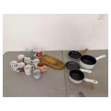 Assorted Kitchen Items: Mugs, Pans, and Cutting Board