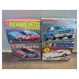 Four Model Car Kits: Revell Charger Funny Car, Monogram GTX 2 in 1, AMT Richard Petty STP Grand Prix, and Polar Lights Richard Petty Dodge Charger