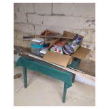 Mixed Residential Table Inventory Including Christmas Tins, Hand Tools, and Sporting Equipment
