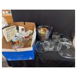 Kitchenware Assortment Including Pyrex Lids, Glass Carafe, Ceramic Mugs, and Wire Basket