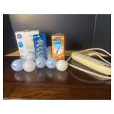 Assorted Household Supplies Including Light Bulbs, Power Strip, and Pens