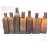 7 Amber Embossed Antique Bottles