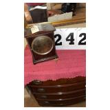 an antique wooden mantel clock, likely dating