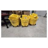 Three yellow commercial mop buckets with wringers.