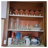 Three shelves of various glasses and other items