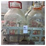 Two Rolling acres half gallon milk jugs in a