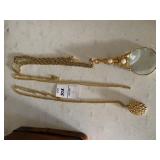 Three necklaces one with an attached magnifying