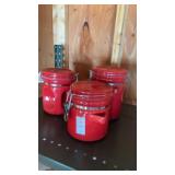 Red ceramic canisters featuring clamp-top lids