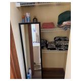 Closet of towels, mirror, bathroom cleaners, hair