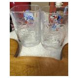 Two Mickey Mouse glasses and wooden cutting board
