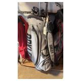 Gray Oakley golf bag with assorted putters