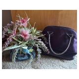 Purple lunch box and faux flower arrangement in