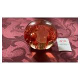 A clear globe paperweight containing suspended