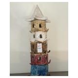 A stacked hand- sculpted clay tower sculpture