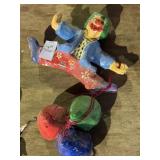Vintage paper mache clown holding onto balloons