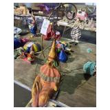 Vintage paper-mache clown seated on a swing with