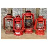 A Collection of Four Red Hurricane Lanterns Includ