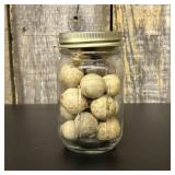 A Collection of Antique Clay Marbles in a Glass St