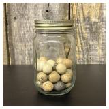 A Collection of Antique Clay Marbles in a Graduate