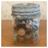 A Collection of Vintage Glass Marbles in a Glass S