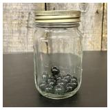 A Collection of Black Galaxy Glass Marbles in a Gr