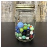 A Collection of Assorted Glass Marbles in a Clear