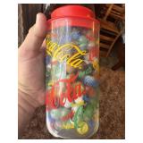 A Collection of Assorted Glass Marbles in a Coca-C