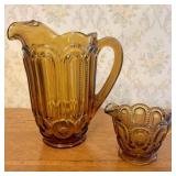 A Pair of Amber Pressed Glass Moon and Star Pitche