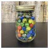 A Collection of Assorted Glass Marbles in a Clear