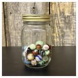 A Collection of Vintage Glass Marbles in a Graduat