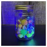A Collection of Vintage Glass Marbles in a Glass S
