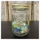 An Assortment of Glass Marbles Stored in a Graduat