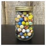 A Collection of Vintage Glass Marbles in a Glass M