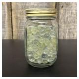 A Collection of Vintage Glass Marbles in a Graduat