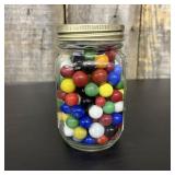 An Assortment of Glass Marbles in a Graduated Glas