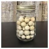 A Collection of Vintage Clay Marbles in a Glass Me