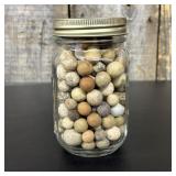 A Collection of Antique Clay Marbles in a Graduate