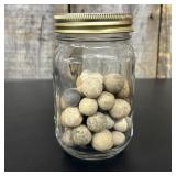 A Collection of Antique Clay Marbles in a Glass Ca