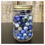 A Collection of Assorted Glass Marbles in a Glass