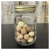 A Collection of Antique Clay Marbles in a Graduate