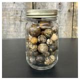 A Collection of Natural Stone and Clay Marbles in