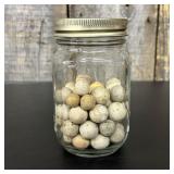 A Collection of Antique Clay Marbles in a Glass Ja