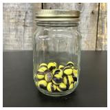 A Collection of Swirl Glass Marbles in a Mason Jar