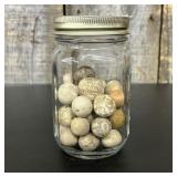 A Collection of Vintage Clay Marbles in a Glass St