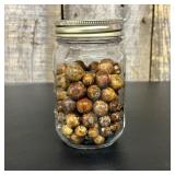 A Collection of Vintage Glass Marbles in a Clear G