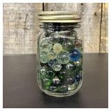 A Collection of Assorted Glass Marbles in a Clear